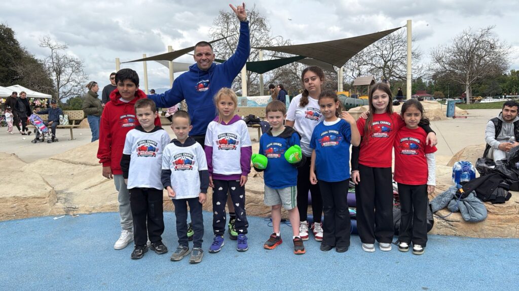 children practicing boxing drills on grass during outdoor event